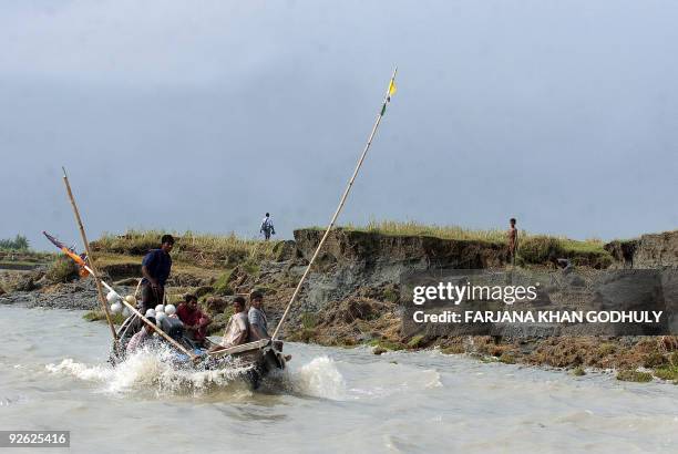 Bangladesh-Britain-aid-environment-climate-warming' by Shafiq Alam Bangladeshi fishermen go fishing near a newly-formed land at Boyer Char on August...