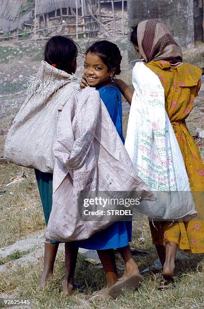 Three Bangladeshi female child labourers, aged between 8 to 12 year's of age, carry their goods in Dhaka, 05 January 2006. Some 2.4 milion children...