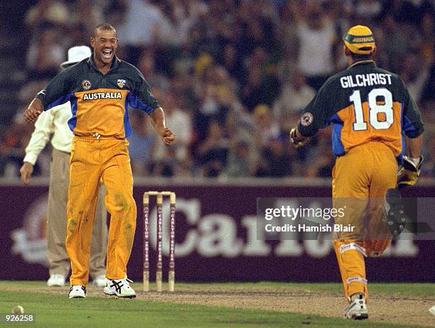 Andrew Symonds of Australia celebrates taking the wicket Mahendra Nagamootoo of the West Indies as Adam Gilchrist runs to congratulate, in the...