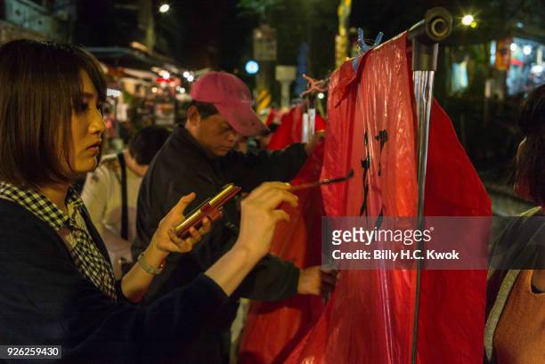 Tourists write on the sky lanterns in Pingxi on March 1, 2018 in Pingxi, Taiwan. Pingxi, a Taiwanese district known for its old train tracks and...