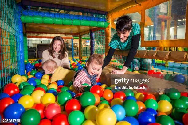 playing in the ball pool - adult ball pit stock pictures, royalty-free photos & images