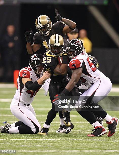 Reggie Bush of the New Orleans Saints is tackled by Mike Schneck and Curtis Lofton of the Atlanta Falcons at the Louisiana Superdome on November 2,...