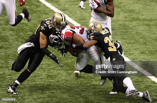 Michael Turner of the Atlanta Falcons carries the ball against Jabar Greer and Scott Shanle of the New Orleans Saints at the Louisiana Superdome on...