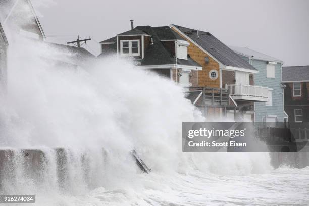 Waves crash over houses on Turner Rd. As a large coastal storm affects the area on March 2, 2018 in Scituate, Massachusetts. A powerful nor'easter is...