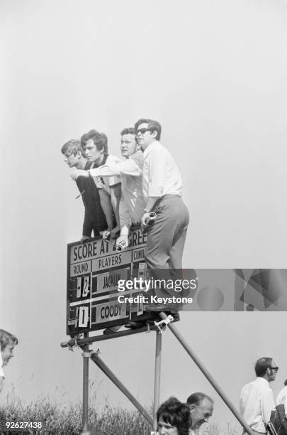 Spectators gain a better view of the green from the top of a scoreboard, during the Open Championship at Royal Birkdale, 9th July 1971. Britain's...