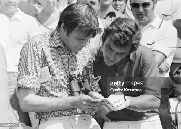 British golfer Tony Jacklin and a referee consult the rule book at the 8th fairway during the Open Championship at Royal Birkdale, 9th July 1971....