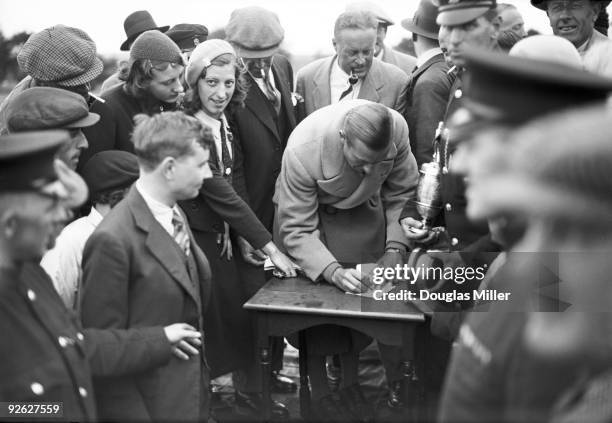 English golfer Henry Cotton signs autographs for fans at the Open Golf Championship, 29th June 1934. Cotton won the championship, which was held at...