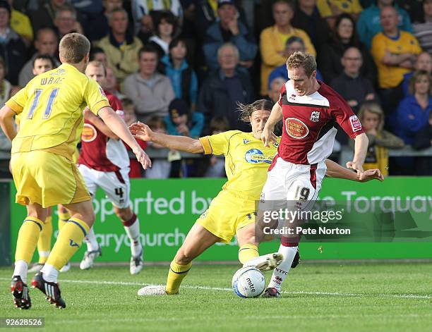 John Curtis of Northampton Town attempts to move past the challenge of Chris Hargeaves of Torquay United during the Coca Cola League Two Match...