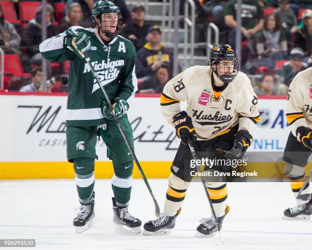 Brent Baltus of the Michigan Tech Huskies follows the play next to Carson Gatt of the Michigan State Spartans during game one of the Great Lakes...