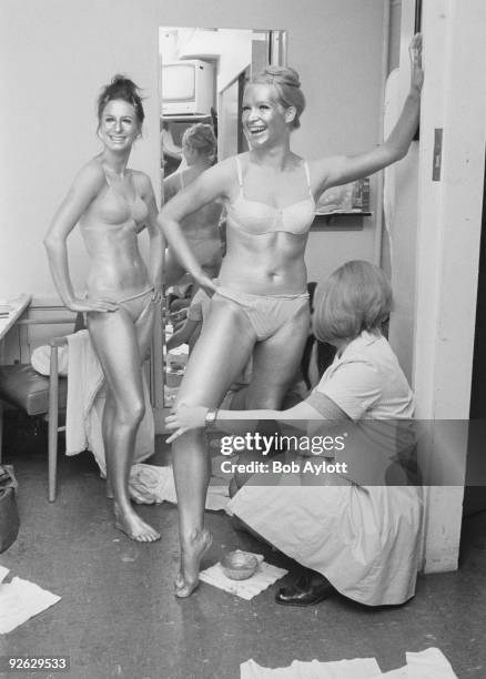 Barbara 'Babs' Lord and Patricia 'Dee Dee' Wilde, of British TV dance troupe Pan's People, being painted gold before their appearance on the...