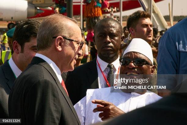 Malian President Ibrahim Boubacar Keita laughs with Turkish president Recep Tayyip Erdogan as he welcomes him upon his arrival at Bamako airport on...