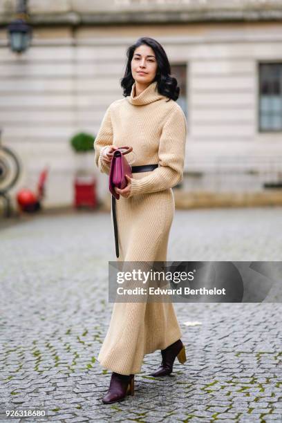 Caroline Issa a beige wool dress with a turtleneck, a red bag, and attends the Nina Ricci show as part of the Paris Fashion Week Womenswear...