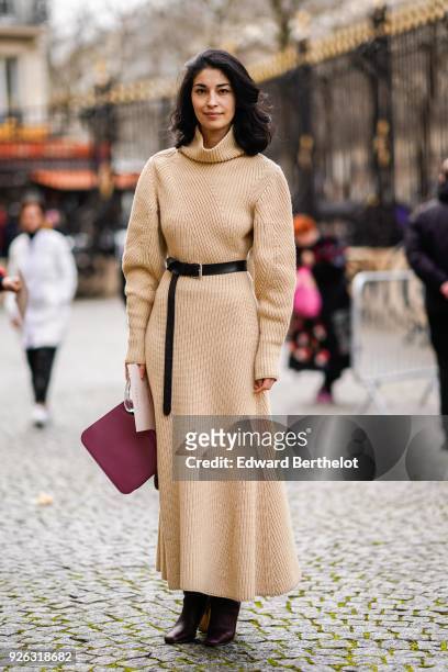 Caroline Issa a beige wool dress with a turtleneck, a red bag, and attends the Nina Ricci show as part of the Paris Fashion Week Womenswear...