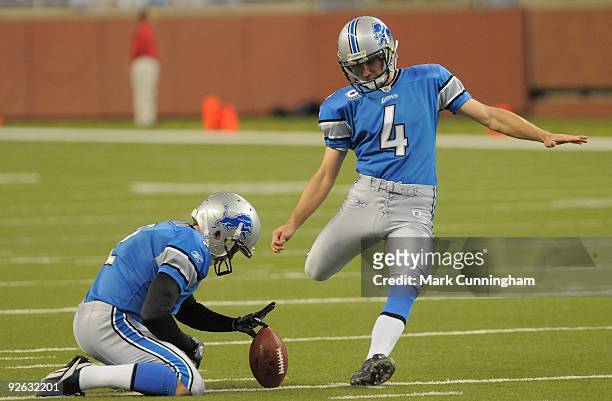 Jason Hanson of the Detroit Lions kicks a field goal during warm-ups while Nick Harris holds the football before the game against the St. Louis Rams...