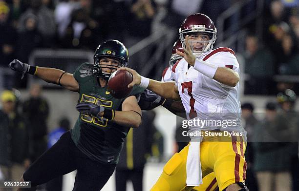 Quarterback Matt Barkley of the USC Trojans sets to throw a pass as linebacker Casey Matthews of the Oregon Ducks applies pressure in the third...