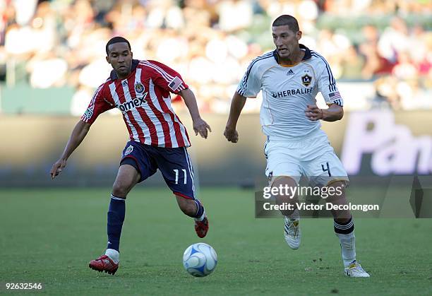 Maykel Galindo of Chivas USA and Omar Gonzalez of the Los Angeles Galaxy pursue the ball during Game 1 of the MLS Western Conference Semifinals match...