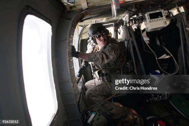 Medic Sgt. Bryan Eickelberg of Arden Heights, Minnesota, with the 82nd Airborne Combat Aviation Brigade, keeps watch in a Medivac helicopter as they...