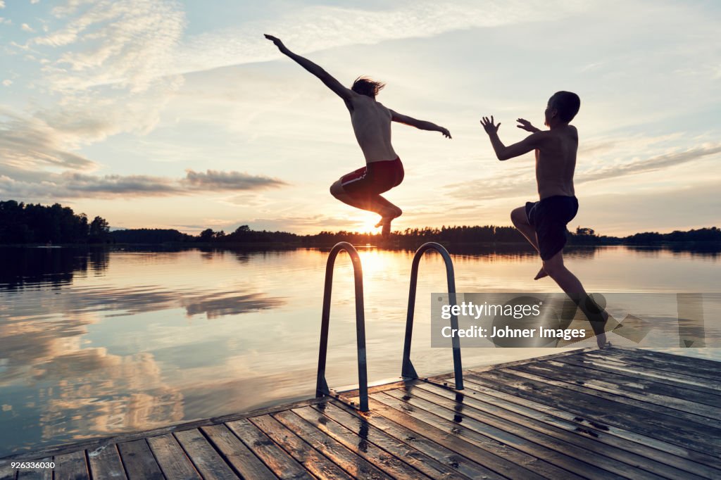 Boys jumping into lake