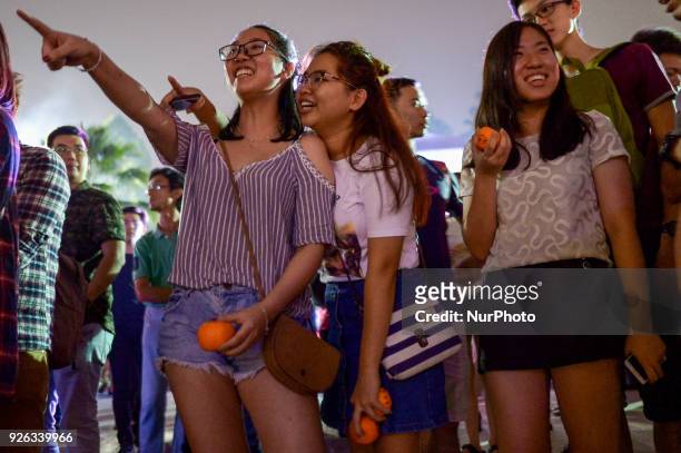 Malaysian ethnic Chinese women gather nearby a lake before throwing mandarin orange written with their wishes and phone number into the lake, marking...