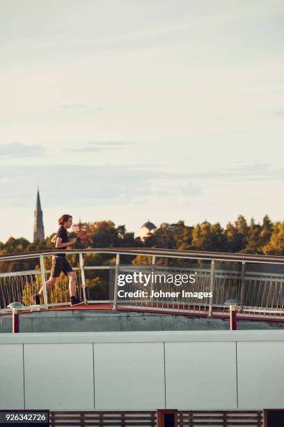 woman jogging through footbridge - uppsala stock pictures, royalty-free photos & images