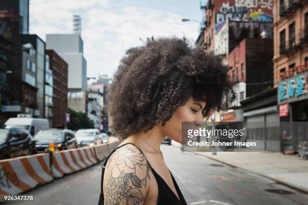 smiling woman looking crossing street - woman tattoo stock pictures, royalty-free photos & images