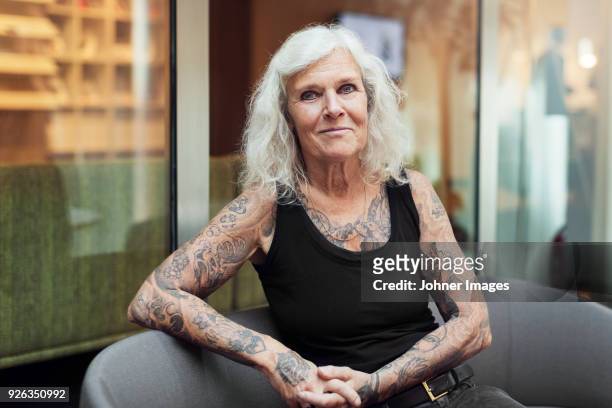 portrait of senior woman with tattoos - tatouage femme photos et images de collection