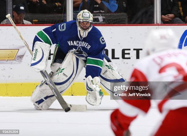 Kris Draper of the Detroit Red Wings looks for a rebound as Roberto Luongo of the Vancouver Canucks makes a save during their game at General Motors...