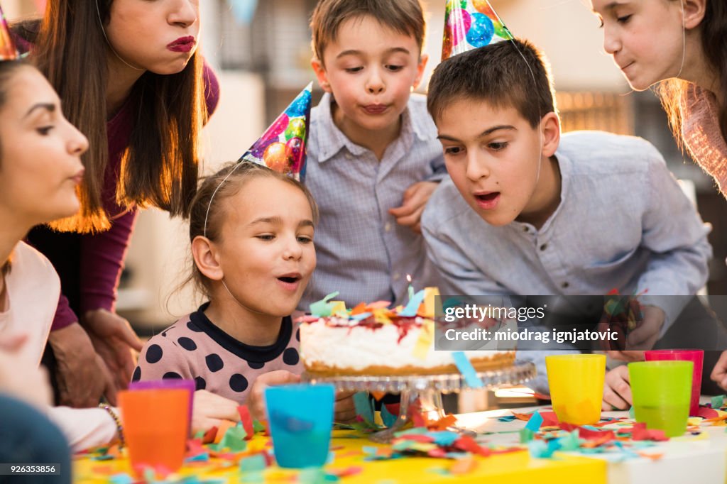 Children Blowing candles on a Birthday party