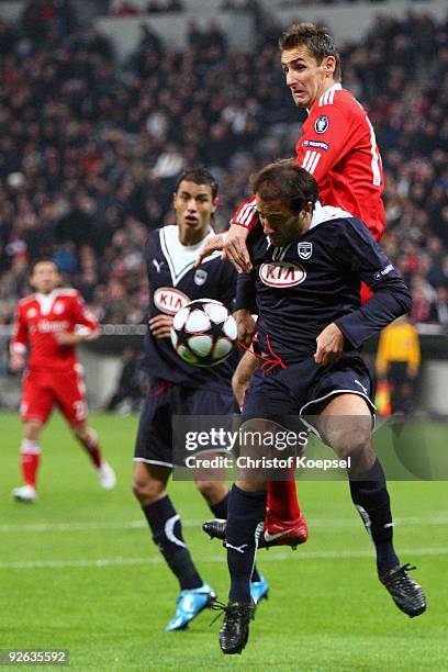 Marc Planus of Bordeaux and Miroslav Klose of Bayern jump for a header during the UEFA Champions League Group A match between FC Bayern Muenchen and...