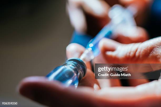 woman preparing an injection at home. - spuit stockfoto's en -beelden