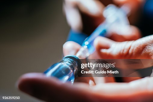 Woman preparing an injection at home. Woman preparing an injection at home.