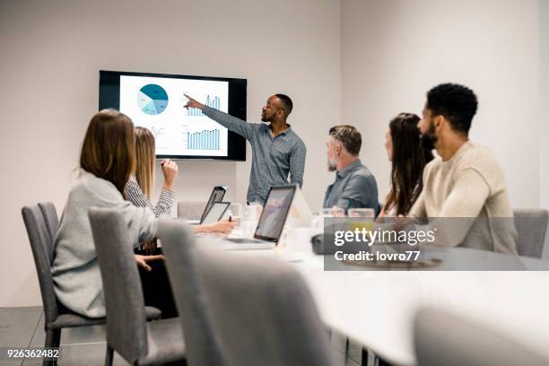 young man has presentation with graph on lcd screen - uk plug socket stock pictures, royalty-free photos & images