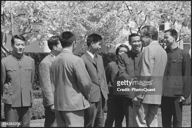 View of members of the Chinese National Table Tennis Team as they shake hands with American politician US President Richard Nixon on the lawn of the...