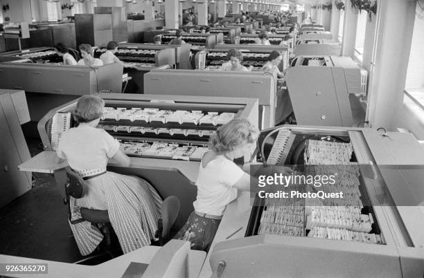 View of employees as they work with personnel cards among the file indexes at FBI Headquarters, Washington DC, August 26, 1956.