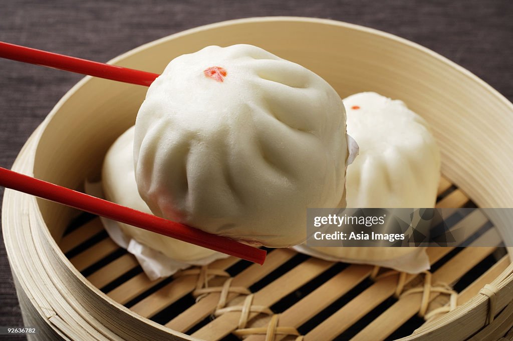 Red chopstick holding dim sum (bao)