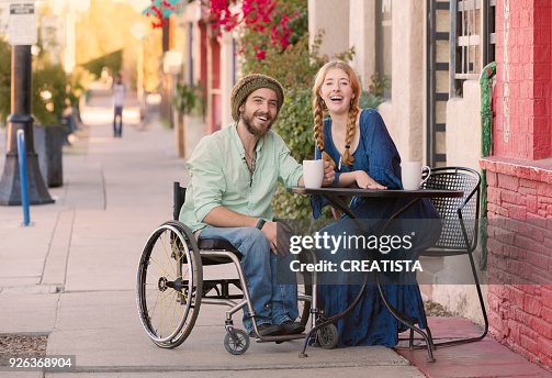 Vrouw met Man in rolstoel aan Cafe tafel Vrouw met Man in rolstoel aan Cafe tafel