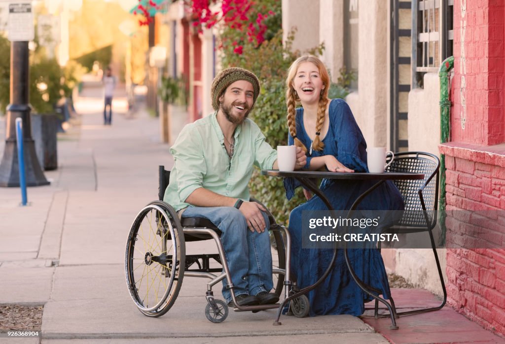 Woman with Man in Wheelchair at Cafe Table