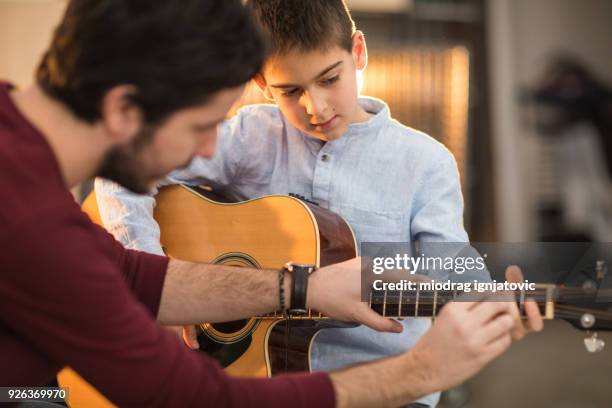 tocar la guitarra con mi hermano - guitarra fotografías e imágenes de stock