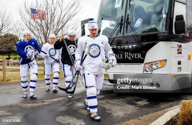 Dominic Moore, Morgan Rielly, Connor Brown, and William Nylander of the Toronto Maple Leafs arrive for practice a day before their outdoor NHL...