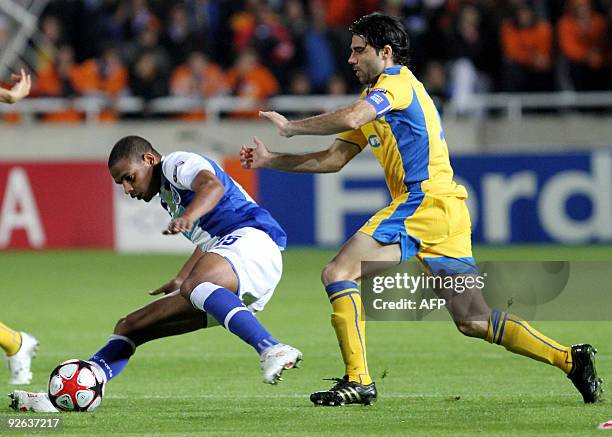 Apoel Nicosia's captain Marinos Stasias competes with FC Porto's Fernando during their UEFA Champions League group D football match at the GSP...