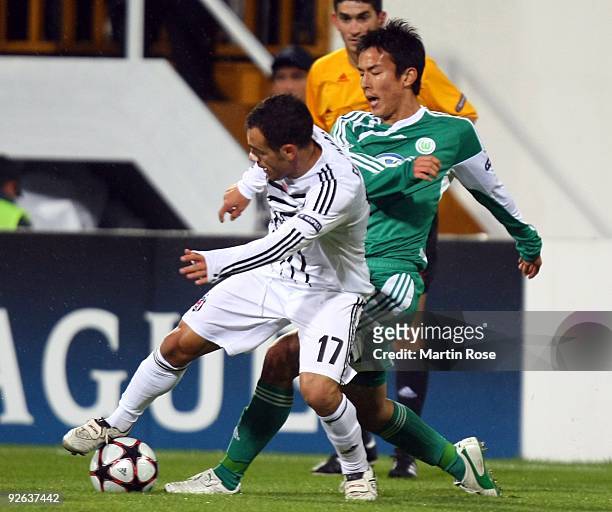 Ekrem Dag of Besiktas and Makoto Hasebe of Wolfsburg compete for the ball during the UEFA Champions League Group B match between Besiktas and VfL...