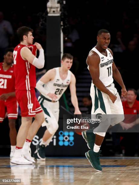 Lourawls Nairn Jr. #11 of the Michigan State Spartans celebrates the win at the buzzer as Ethan Happ of the Wisconsin Badgers reacts during...