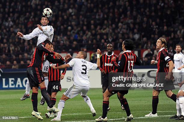Real Madrid's defender Raul Albiol heads the ball pas AC Milan players during their UEFA Champions League group stage football match on November 3,...