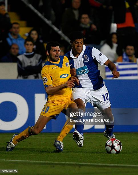 Apoel Nicosia's Marios Elia vies for the ball with FC Porto's Hulk during their UEFA Champions League group D football match at the GSP Stadium in...