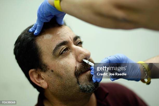 Ribhi Salim receives an H1N1 nasal flu spray vaccine from Marina Spelzini, a registered nurse, at the Miami Dade County Health Department downtown...