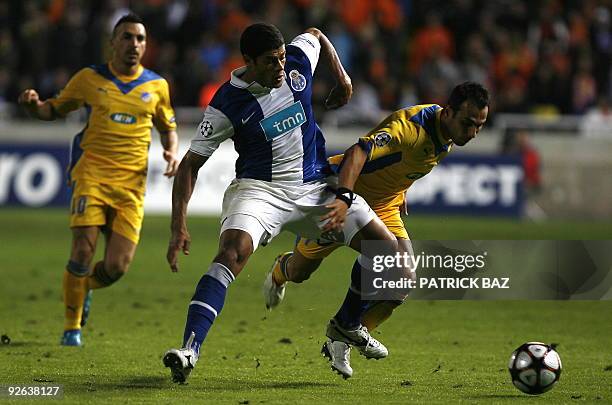 Apoel Nicosia's Savvas Poursaitides vies for the ball with FC Porto's Hulk during their UEFA Champions League group D football match at the GSP...