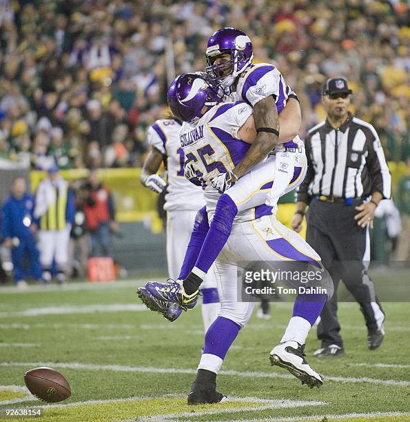 Bernard Berrian of the Minnesota Vikings celebrates a touchdown catch with teammate John Sullivan during an NFL game against the Green Bay Packers at...