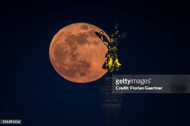 The full moon rises behind the so called 'Goldelse' on the top of the Berlin Victory Column on March 02, 2018 in Berlin, Germany.
