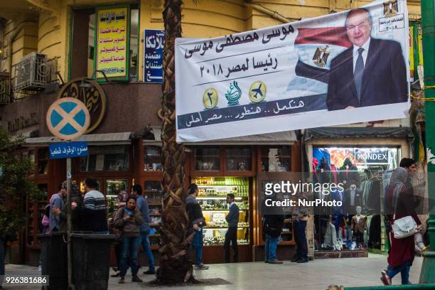 Egyptians walk underneath an election campaign banner erected by supporters of supporters of Ghad Party chairperson Moussa Mostafa Moussa in Cairo,...