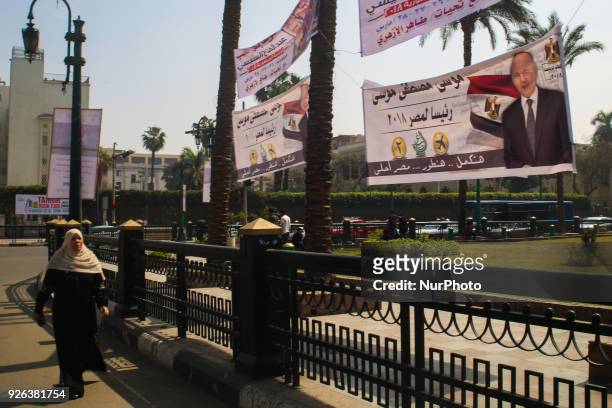 Egyptians walk underneath an election campaign banner erected by supporters of supporters of Ghad Party chairperson Moussa Mostafa Moussa in Cairo,...